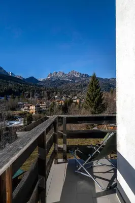 a stroller on a balcony with mountains in the background at Ciasa Marian 10 minutes from Cortina with free parking! in Borca di Cadore