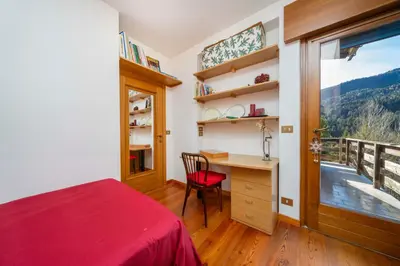 a bedroom with a desk and a window at Ciasa Marian 10 minutes from Cortina with free parking! in Borca di Cadore