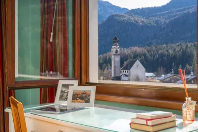 a desk with a window with a clock tower in the background at Ciasa Marian 10 minutes from Cortina with free parking! in Borca di Cadore