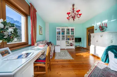a living room with a bed and a desk at Ciasa Marian 10 minutes from Cortina with free parking! in Borca di Cadore