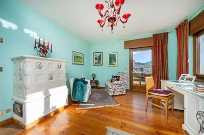 a living room with blue walls and a chandelier at Ciasa Marian 10 minutes from Cortina with free parking! in Borca di Cadore