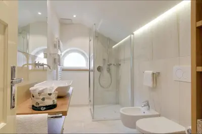 a bathroom with a shower and a toilet and a sink at Apartment Laura in Ortisei