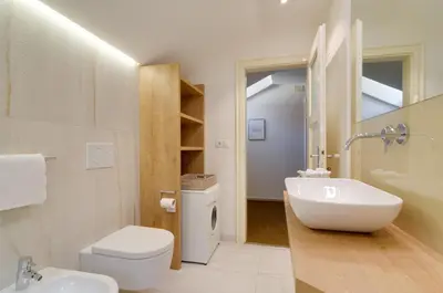 a white bathroom with a sink and a toilet at Apartment Laura in Ortisei