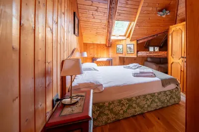 a bedroom with a bed in a wooden cabin at Picia Ciasa - Charming attic in paradise in San Vito di Cadore