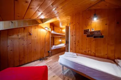 a bedroom with wooden walls and a bed in a room at Picia Ciasa - Charming attic in paradise in San Vito di Cadore