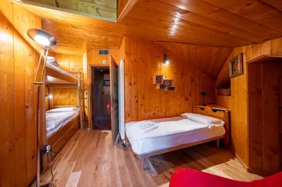 a bedroom with two beds in a wooden cabin at Picia Ciasa - Charming attic in paradise in San Vito di Cadore