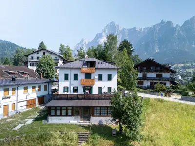 a group of buildings with mountains in the background at Picia Ciasa - Charming attic in paradise in San Vito di Cadore