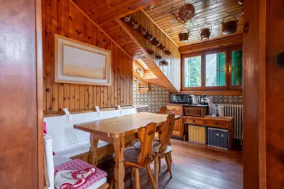 a kitchen with a wooden table and wooden walls at Picia Ciasa - Charming attic in paradise in San Vito di Cadore