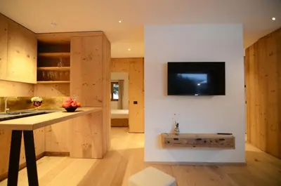 a kitchen with wooden cabinets and a tv on the wall at Villa Primavera in Alvera