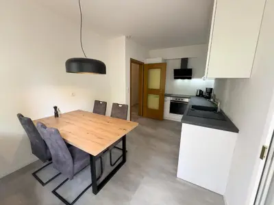a kitchen and dining room with a wooden table and chairs at Apartment Annabell - Alpstay in Naturno