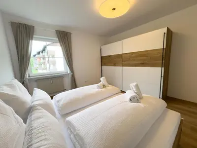 two beds in a bedroom with white sheets at Apartment Annabell - Alpstay in Naturno