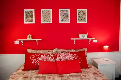 a bedroom with red walls and a bed with red pillows at Albergo al Sole in Val di Zoldo