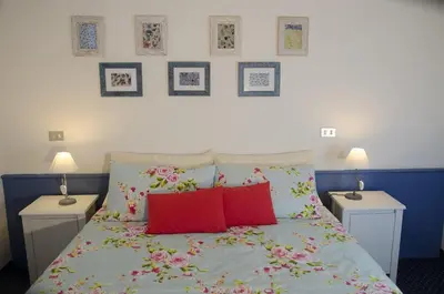 a bedroom with a bed with two tables and two lamps at Albergo al Sole in Val di Zoldo
