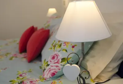 a lamp with a heart on it next to a bed at Albergo al Sole in Val di Zoldo