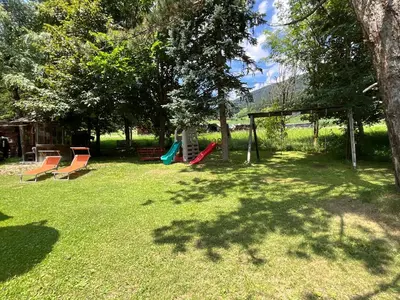 a yard with a playground with chairs and a swing at Appartements Oberhammer in Tesido