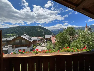 a view of a town from a balcony with flowers at Appartements Oberhammer in Tesido