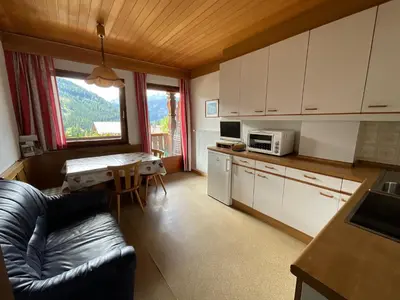 a kitchen with a couch and a table with a microwave at Appartements Oberhammer in Tesido