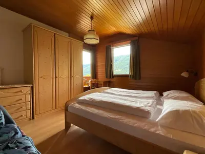 a bedroom with a large bed with a wooden ceiling at Appartements Oberhammer in Tesido