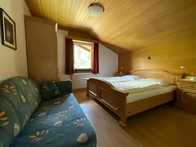 a bedroom with a bed and a couch in a room at Appartements Oberhammer in Tesido