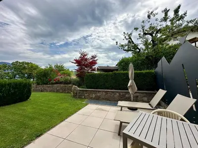 a patio with a table and chairs in a yard at Felsenegg appartements in Vollan