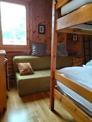 a bunk bed and a couch in a room at VAL DI FASSA CENTRAL HOUSE - Rooms with free parking in Canazei