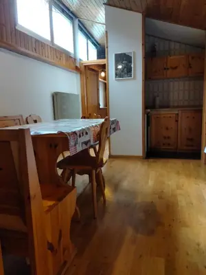 a kitchen with a table and chairs in a room at VAL DI FASSA CENTRAL HOUSE - Rooms with free parking in Canazei