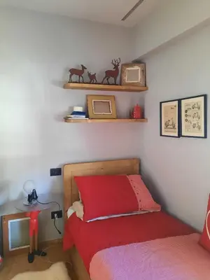 a bedroom with a bed and a table and shelves at Esclusivo soggiorno a Cortina d'Ampezzo in Cortina dʼAmpezzo