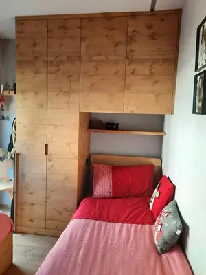 a bedroom with a bed with a wooden cabinet at Esclusivo soggiorno a Cortina d'Ampezzo in Cortina dʼAmpezzo