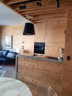 a kitchen with a sink and a living room at Esclusivo soggiorno a Cortina d'Ampezzo in Cortina dʼAmpezzo