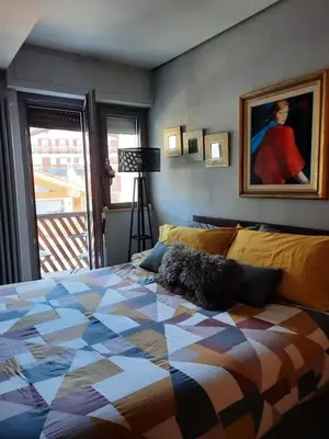 a bedroom with a bed and a painting on the wall at Esclusivo soggiorno a Cortina d'Ampezzo in Cortina dʼAmpezzo