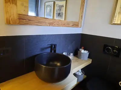 a bathroom with a black sink and a mirror at Esclusivo soggiorno a Cortina d'Ampezzo in Cortina dʼAmpezzo