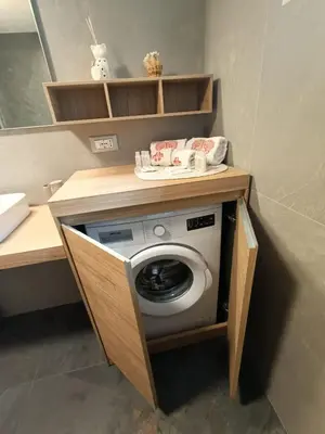 a washer and dryer under a counter in a bathroom at Casa Soraya 2 in Falcade