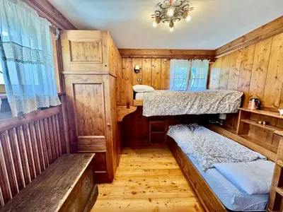 a room with two bunk beds and a chandelier at Ca del Rio - Cortina in Cortina dʼAmpezzo
