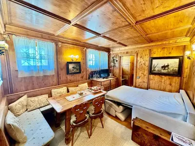 a bedroom with a bed and a table and chairs at Ca del Rio - Cortina in Cortina dʼAmpezzo