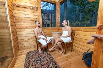 a man and woman sitting in a sauna at Forest Chalet Resort FELIZITAS in San Felice