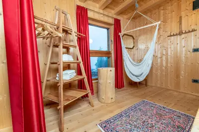 a room with a bed and a hammock at Forest Chalet Resort FELIZITAS in San Felice