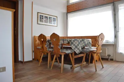 a dining room with a table and four chairs at Appartamenti Donatella in Cavalese