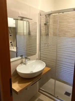 a bathroom with a sink and a glass shower at Casa Solidea in Moena