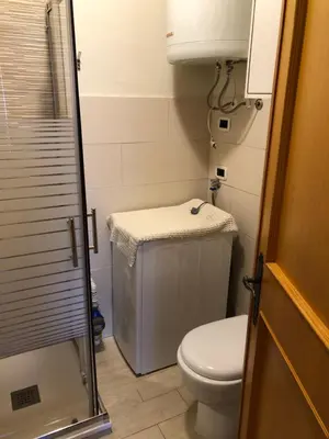 a small bathroom with a toilet and a shower at Casa Solidea in Moena