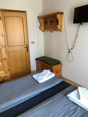 a bedroom with a bed and a door and a television at Casa Solidea in Moena