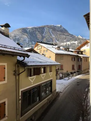 a street with buildings and a mountain in the background at Casa Solidea in Moena