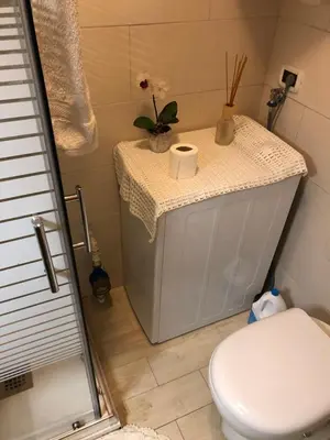 a bathroom with a white toilet and a sink at Casa Solidea in Moena