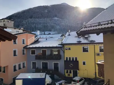 a group of buildings with the sun in the background at Casa Solidea in Moena