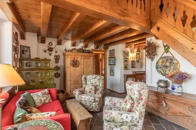 a living room with a red couch and chairs at Casa Scoiattolo, con balcone panoramico in San Vito di Cadore