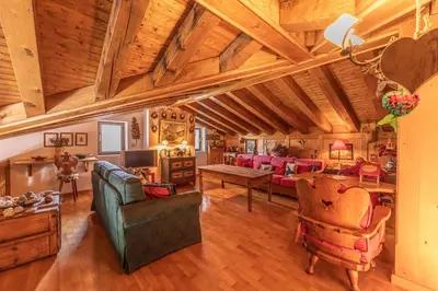 a large living room with a wooden ceiling at Casa Scoiattolo, con balcone panoramico in San Vito di Cadore