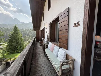 a balcony with benches and a view of the mountains at Casa Scoiattolo, con balcone panoramico in San Vito di Cadore