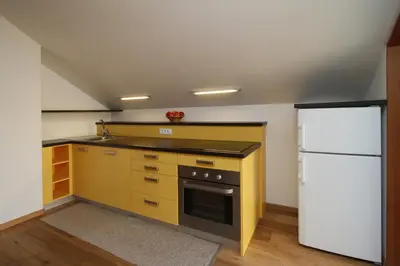 a kitchen with a stove and a white refrigerator at Ferienwohnung Pirchner in San Lorenzo di Sebato