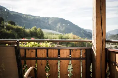 a wooden bench sitting on a balcony with a view at Moarhof Albeins in Albes
