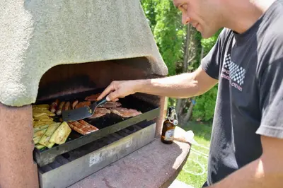 a man cooking meat and vegetables on a grill at Moarhof Albeins in Albes