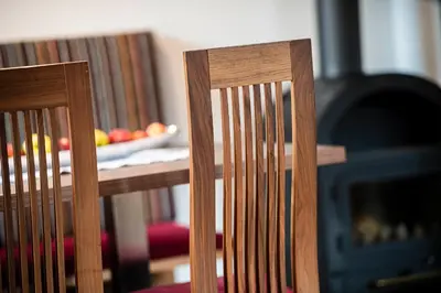 two wooden chairs in front of a fire place at Moarhof Albeins in Albes